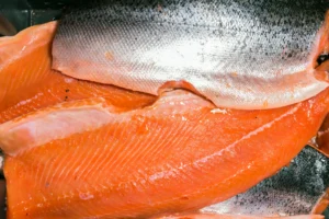 Natural foods. Close-up of raw salmon fillets showing the bright orange flesh and silvery skin.