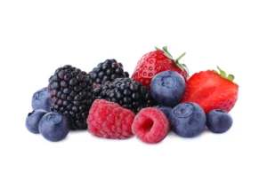 Natural foods. A pile of assorted fresh berries, including blackberries, raspberries, blueberries, and strawberries, on a white background.